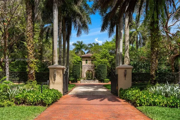 a view of a pathway with a fountain and plants