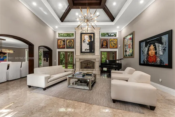 a living room with furniture a fireplace and a chandelier