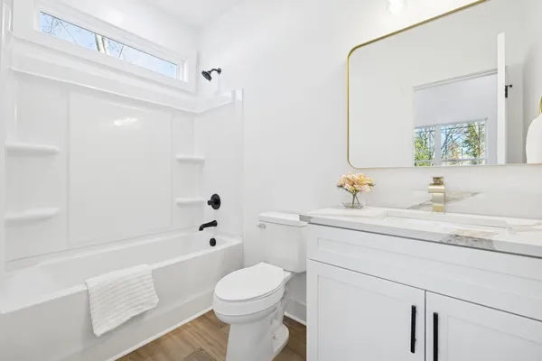 a bathroom with a sink a toilet and shower