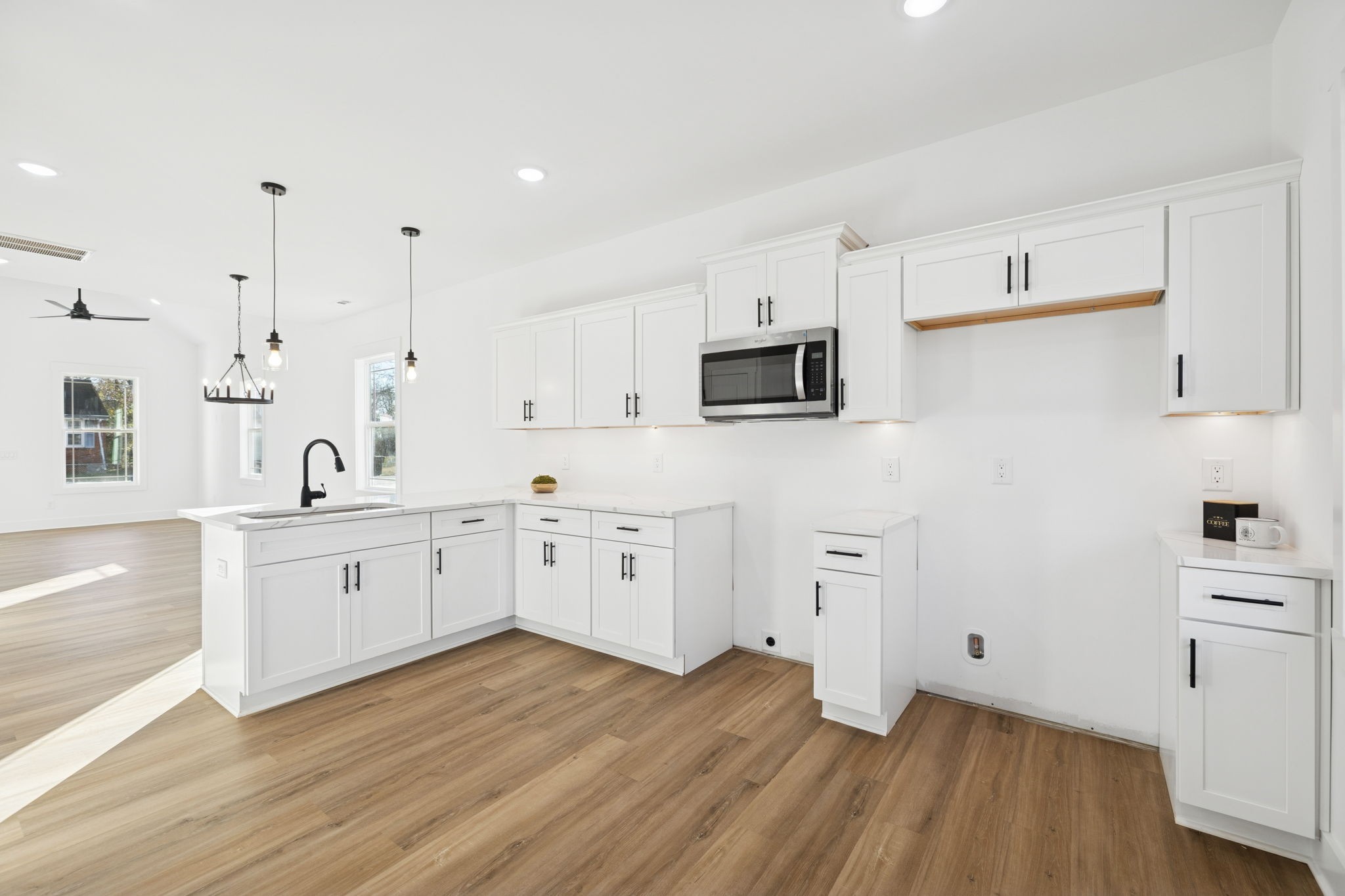 1511 Cheatham Street Springfield, TN 37172 - Photo 10 of 24 a large white kitchen with cabinets stainless steel appliances a sink and wooden floor