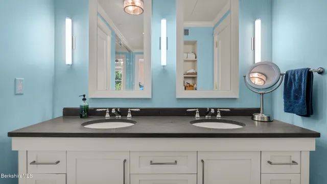 a bathroom with double sink and a mirror
