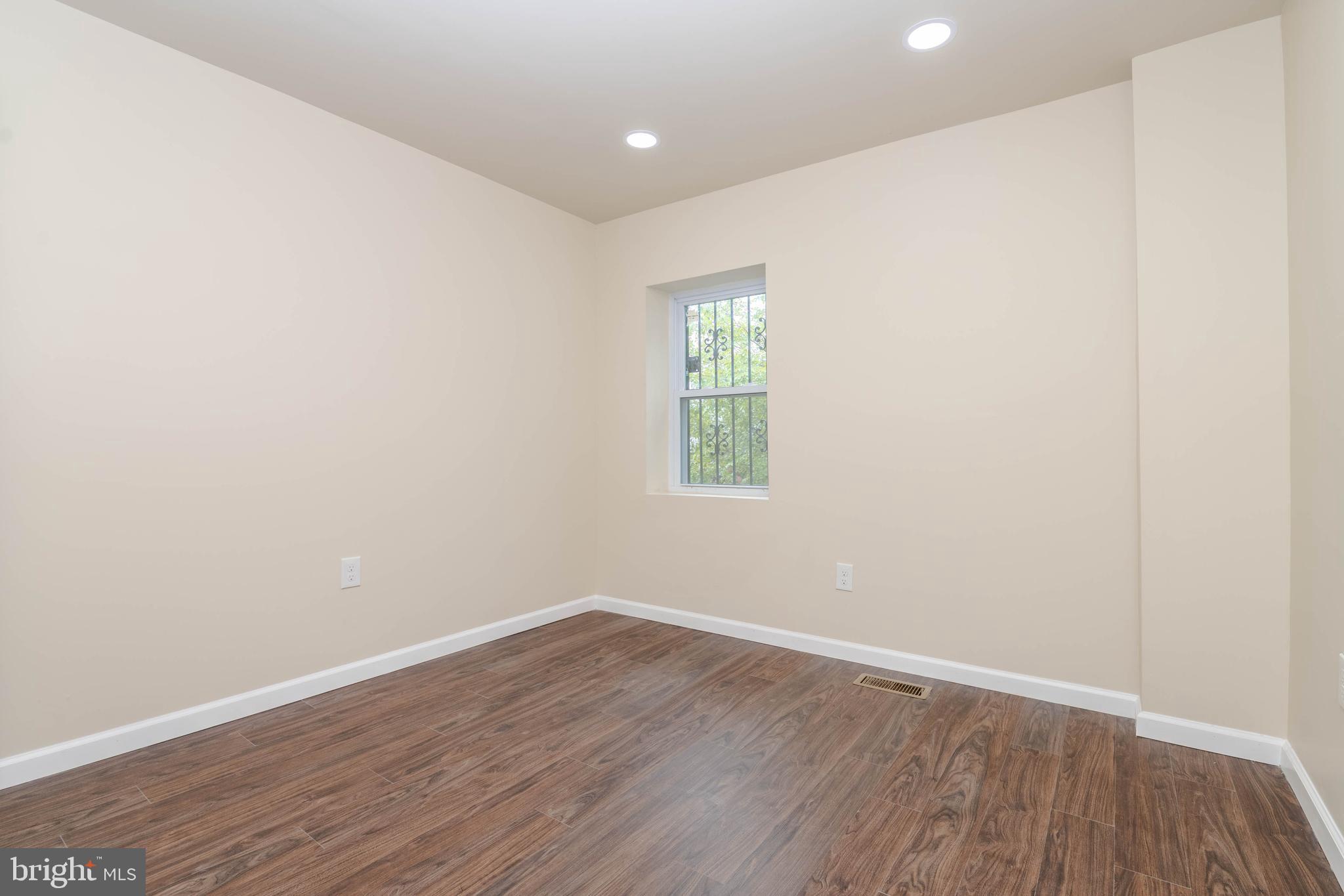 1839 Ramsay Street Baltimore, MD 21223 - Photo 15 of 22 an empty room with wooden floor and window