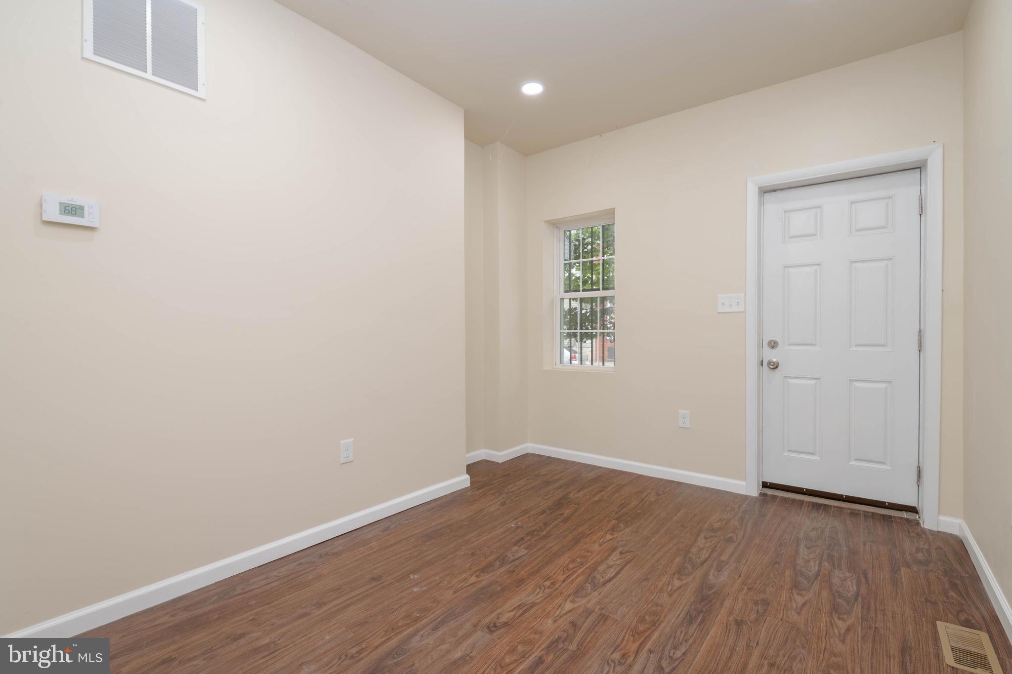 1839 Ramsay Street Baltimore, MD 21223 - Photo 3 of 22 an empty room with wooden floor and windows