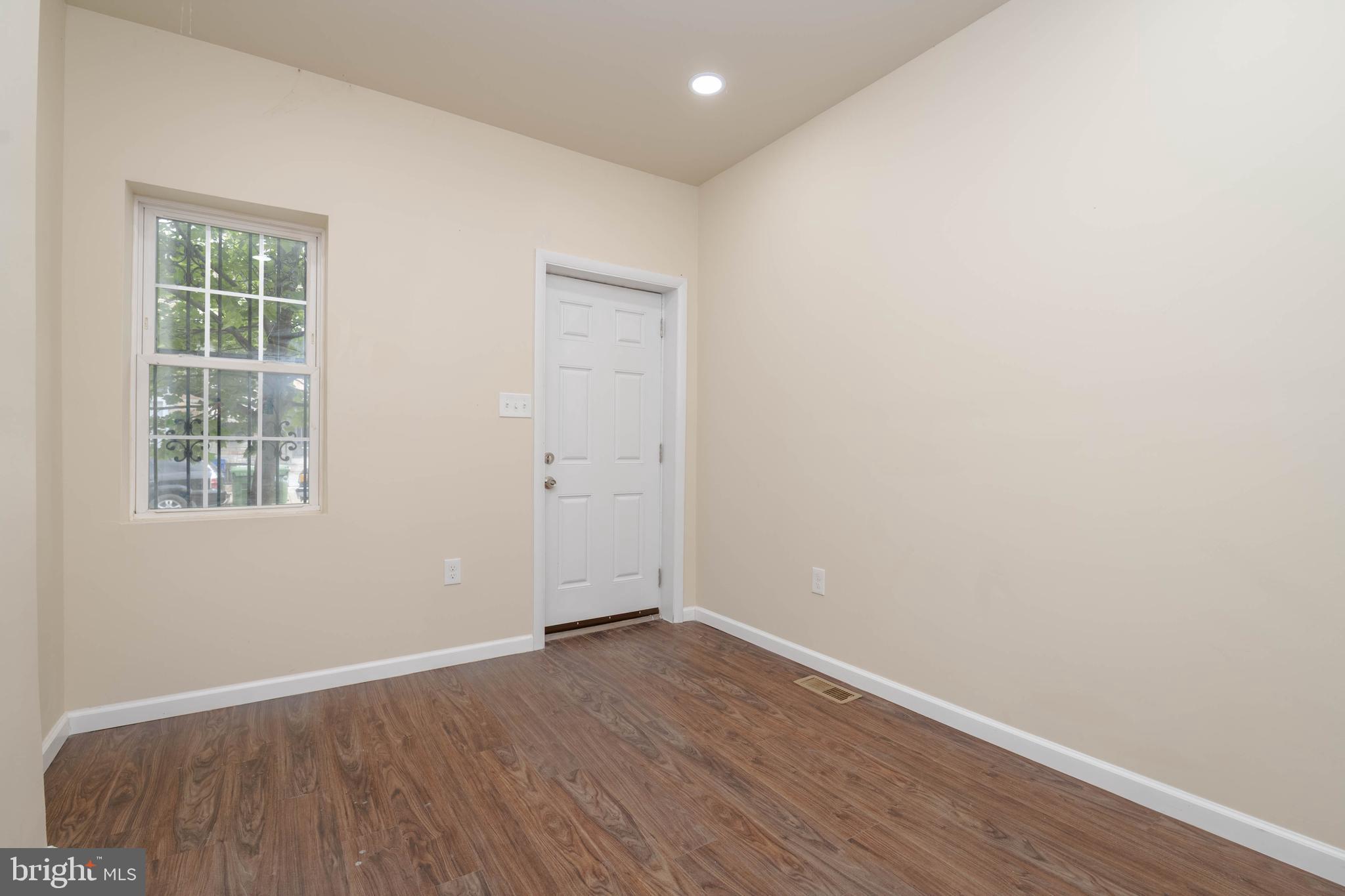 1839 Ramsay Street Baltimore, MD 21223 - Photo 4 of 22 an empty room with wooden floor and windows