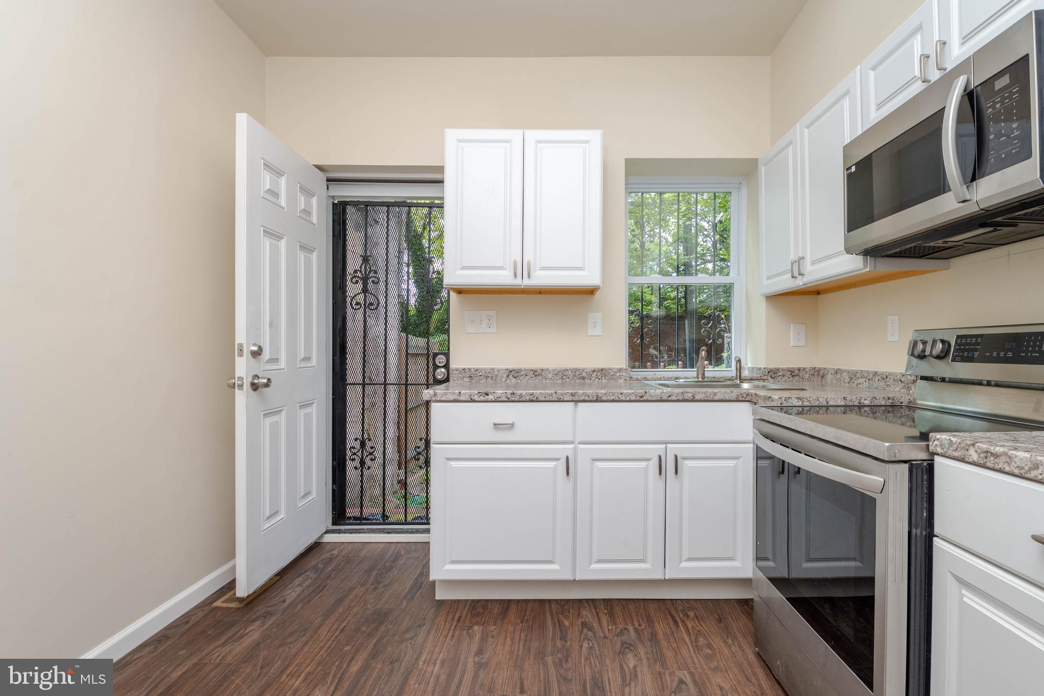 1839 Ramsay Street Baltimore, MD 21223 - Photo 6 of 22 a kitchen with stainless steel appliances granite countertop a stove and a microwave