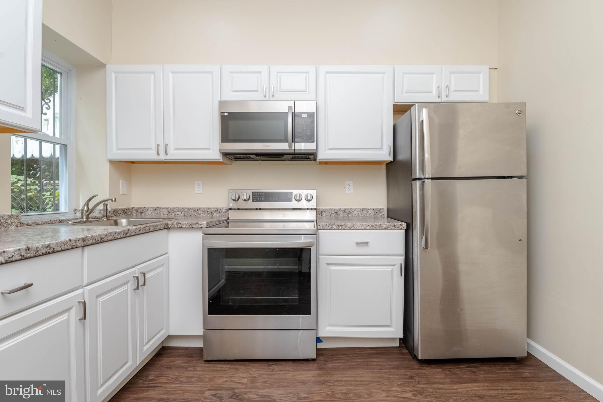 1839 Ramsay Street Baltimore, MD 21223 - Photo 8 of 22 a kitchen with white cabinets and white appliances