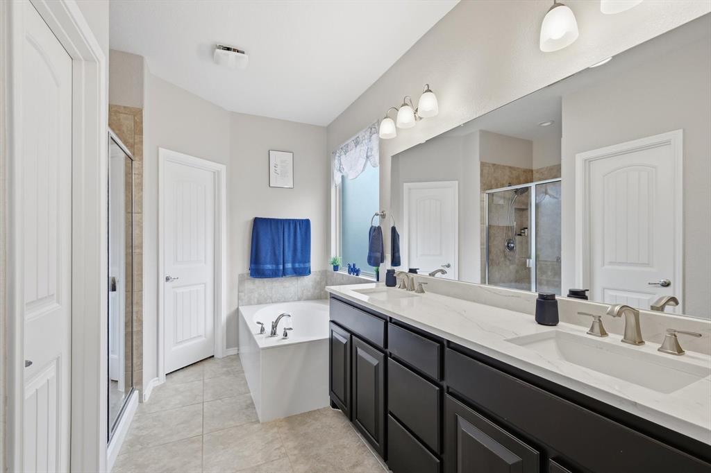 11500 Starlight Ranch Fort Worth, TX 76052 - Photo 21 of 40 The bathroom features a deep soaking tub, a stand-up shower with a glass enclosure, a double vanity with ample counter space, and a large mirror