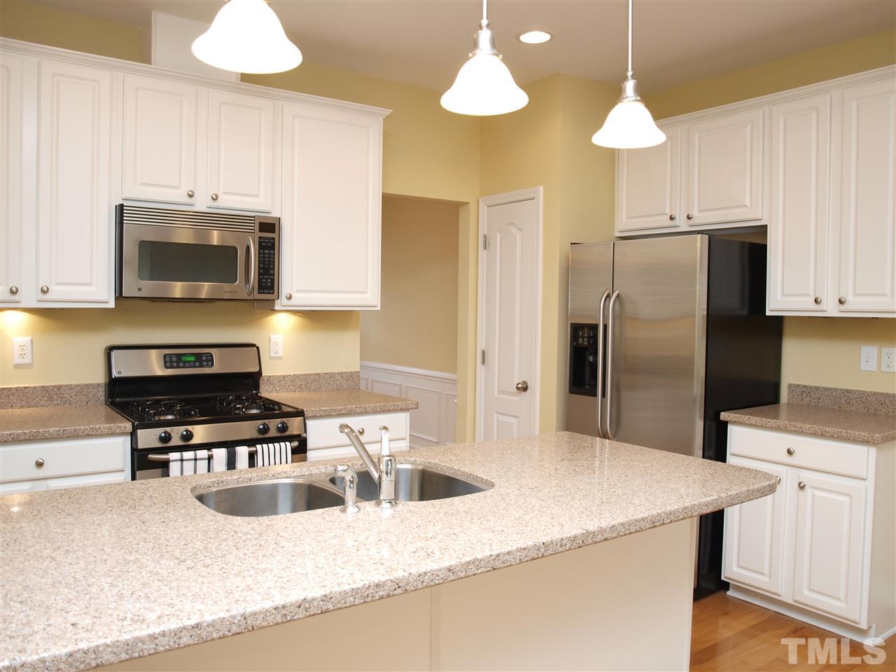 3609 Cathedral Bell Road Raleigh, NC 27614 - Photo 6 of 23 a kitchen with stainless steel appliances a stove a sink and a refrigerator
