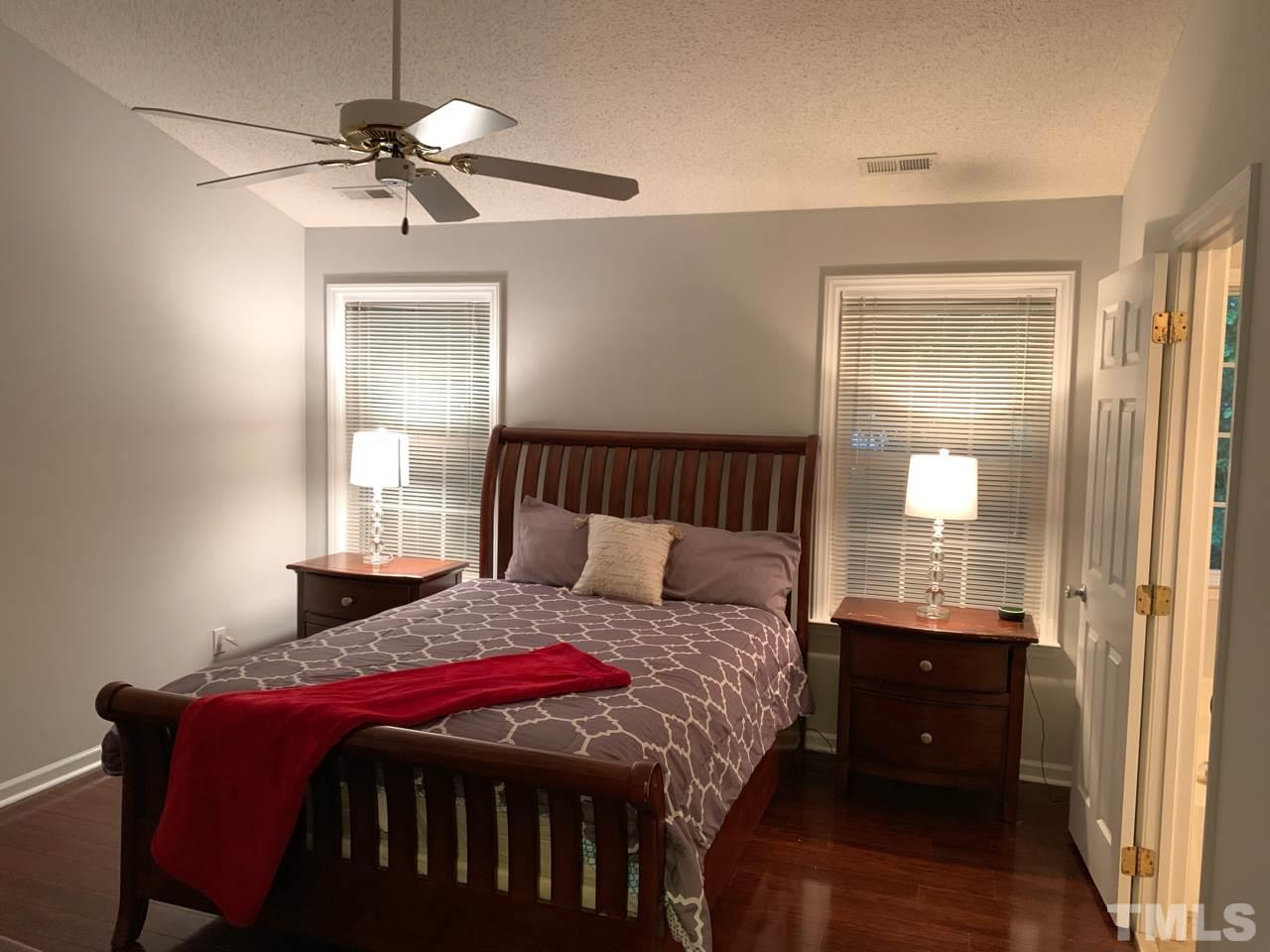 4516 Drewbridge Way Raleigh, NC 27604 - Photo 11 of 23 a bedroom with a bed and a chandelier