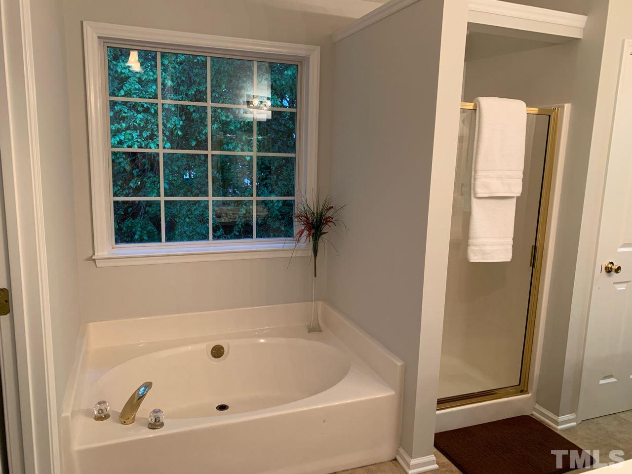 4516 Drewbridge Way Raleigh, NC 27604 - Photo 13 of 23 a bathroom with a bathtub and a window