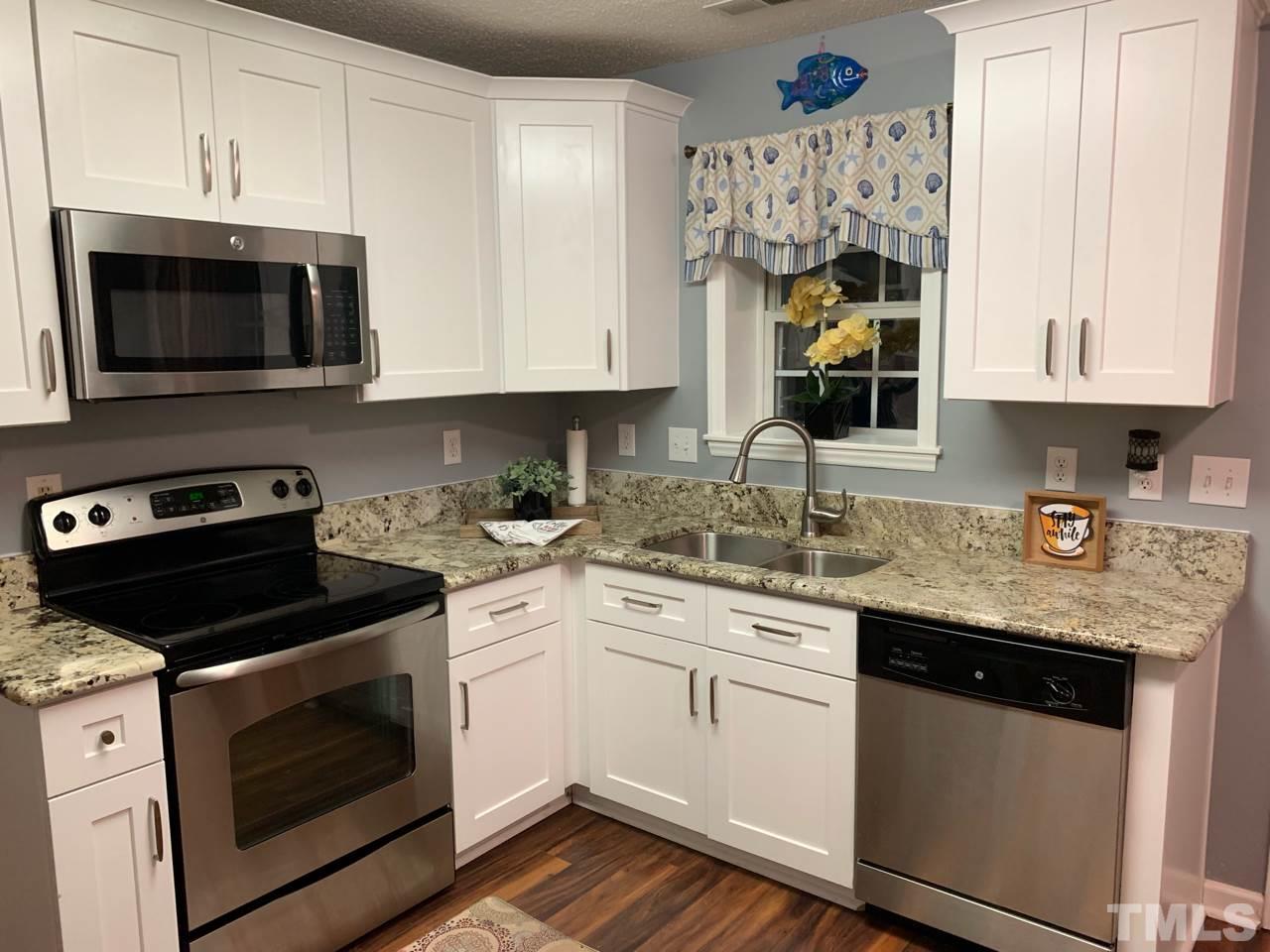 4516 Drewbridge Way Raleigh, NC 27604 - Photo 8 of 23 a kitchen with stainless steel appliances granite countertop a sink a stove and microwave