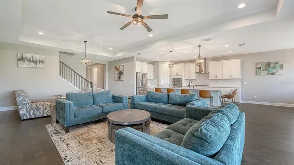 a kitchen with stainless steel appliances a stove a sink island and a refrigerator with wooden floor
