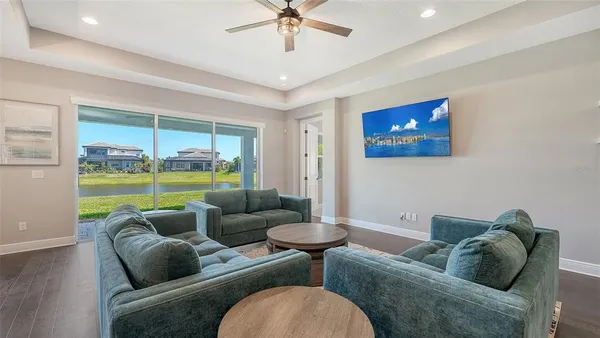 a kitchen with stainless steel appliances granite countertop a stove a refrigerator a sink a dining table and chairs with wooden floor