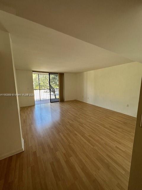 8015 Southwest 107th Avenue, Unit 201 Miami, FL 33173 - Photo 5 of 24 wooden floor in an empty room with a window