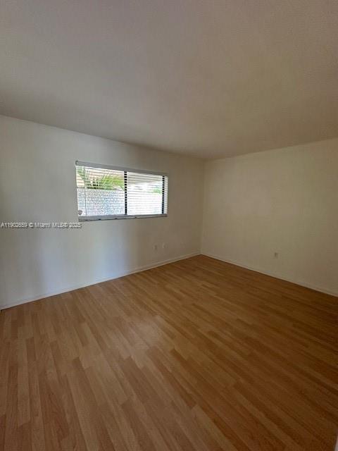 8015 Southwest 107th Avenue, Unit 201 Miami, FL 33173 - Photo 10 of 24 an empty room with wooden floor and windows