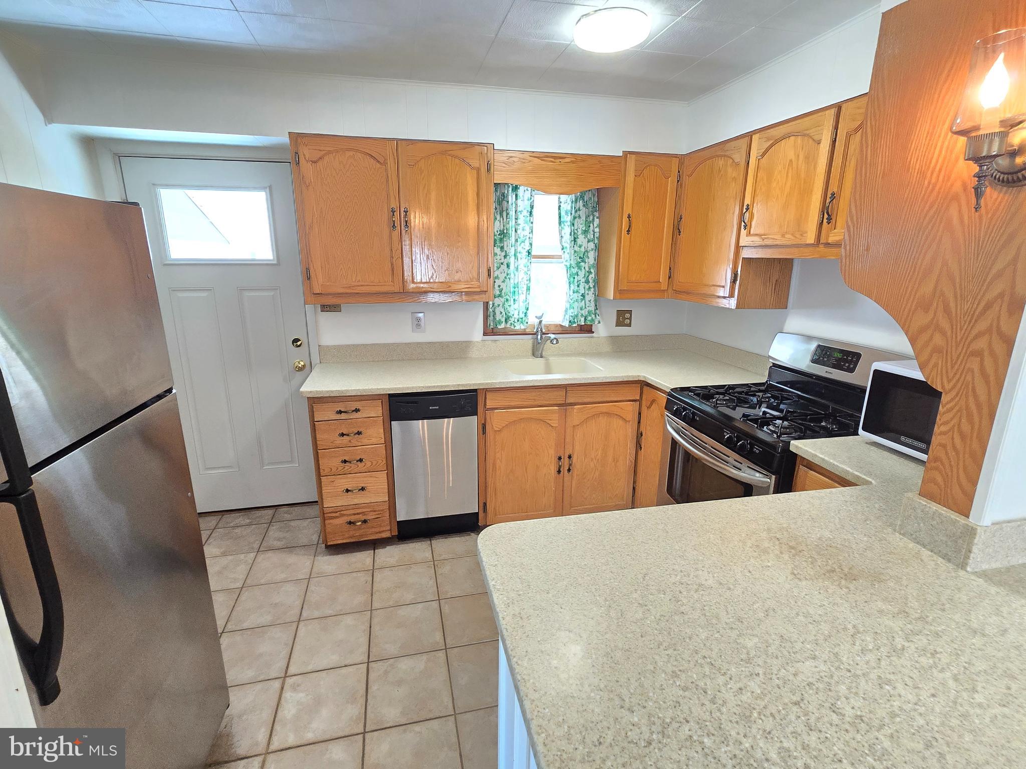 8193 Gumtree Drive Dundalk, MD 21222 - Photo 2 of 26 a kitchen with stainless steel appliances granite countertop a sink counter space cabinets and a large window