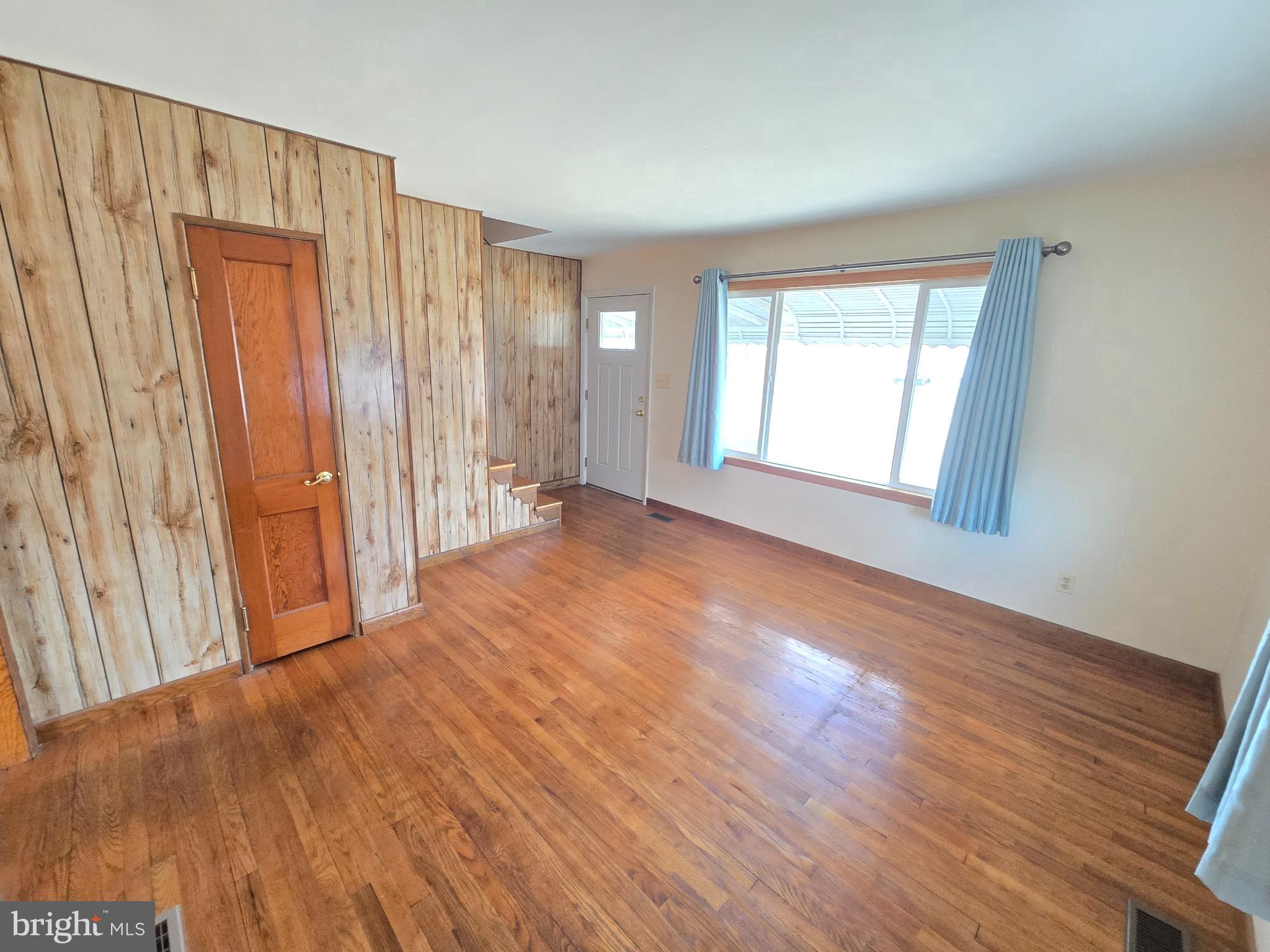 8193 Gumtree Drive Dundalk, MD 21222 - Photo 5 of 26 a view of an empty room with wooden floor and a window