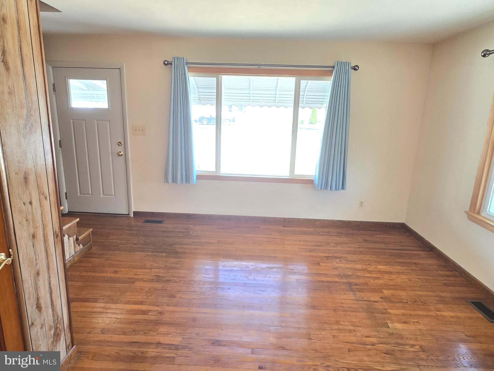 8193 Gumtree Drive Dundalk, MD 21222 - Photo 6 of 26 an empty room with wooden floor and windows