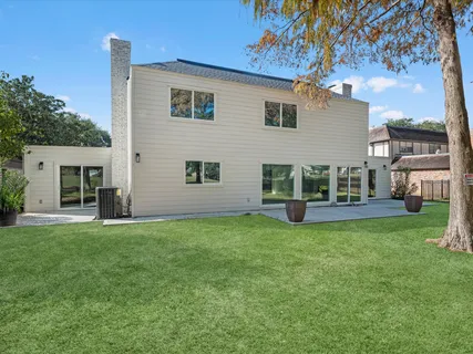a view of a house with backyard and a tree