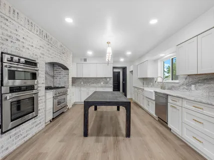 a kitchen with granite countertop wooden floor cabinets and window