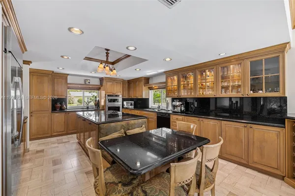 a kitchen with stainless steel appliances granite countertop a sink a stove and a refrigerator
