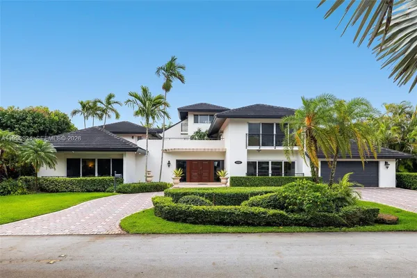 a front view of a house with a yard and potted plants