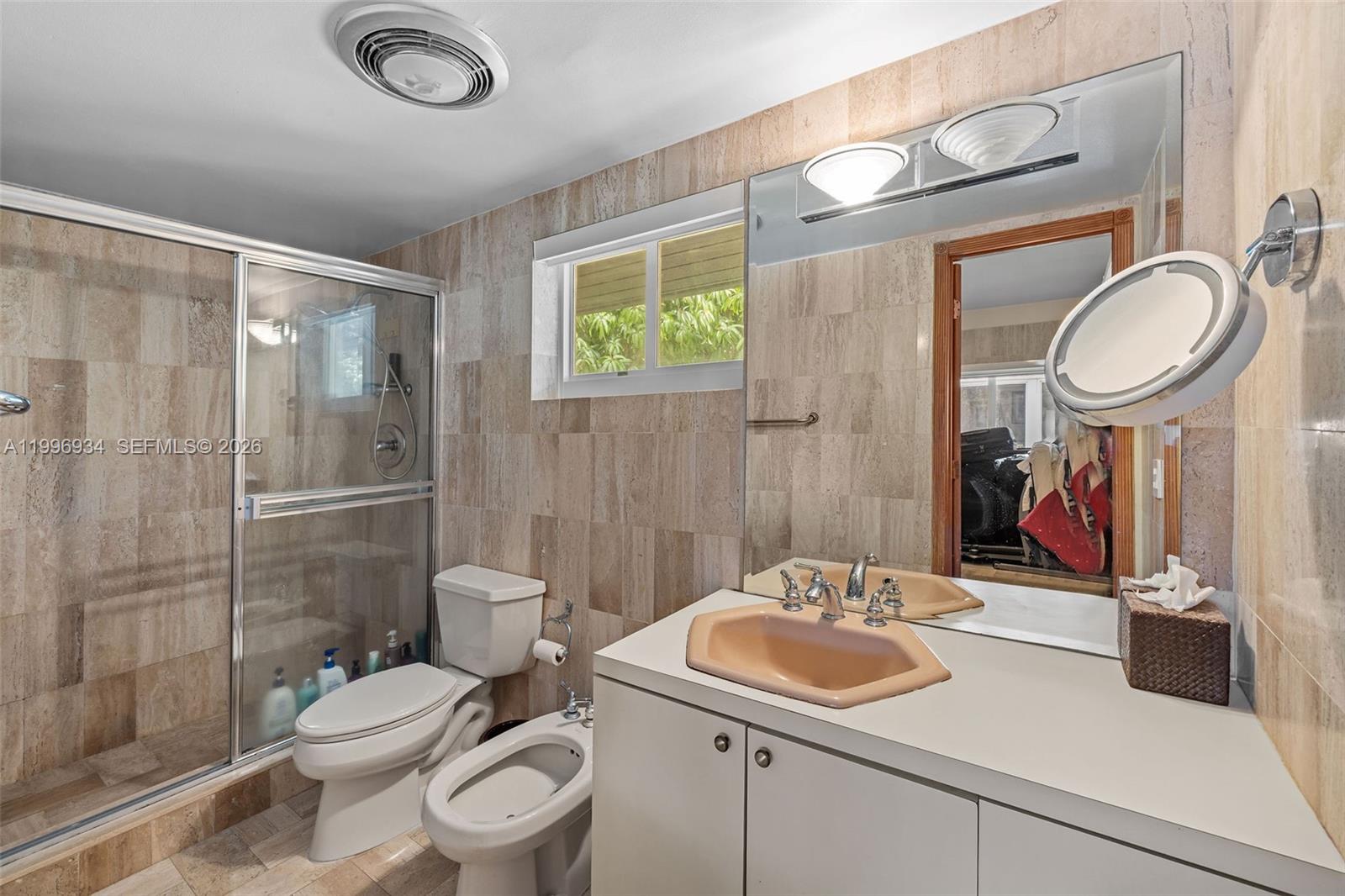 8450 Southwest 74th Terrace Miami, FL 33143 - Photo 33 of 54 a bathroom with a granite countertop toilet a sink a mirror and a shower