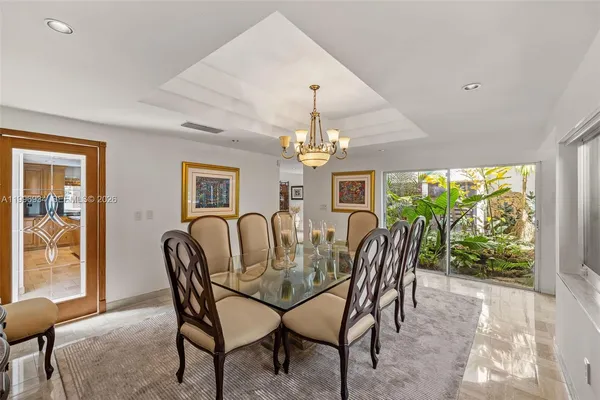 a kitchen with stainless steel appliances granite countertop a stove a refrigerator a kitchen island a table and chairs