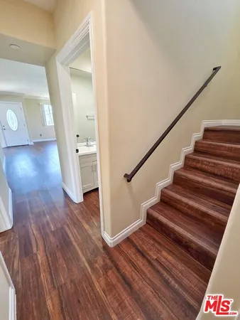 a view of a hallway with wooden floor and staircase