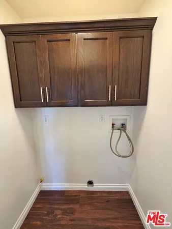 a view of a storage and utility room with wooden floor