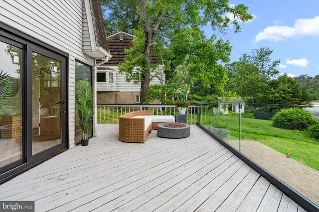 a view of a patio with table and chairs and floor to ceiling window with wooden fence
