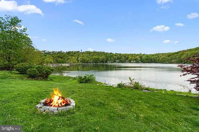 a lake view with a big yard and large trees