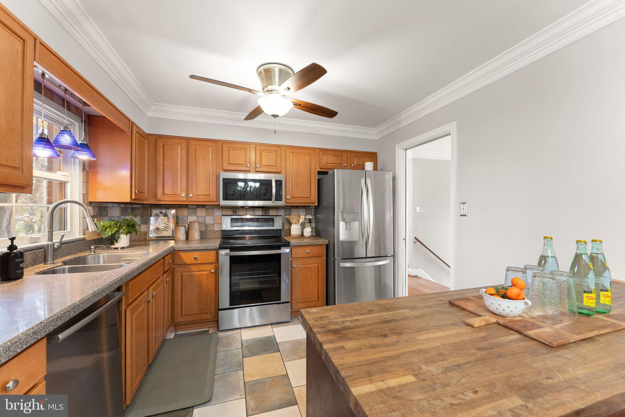 6101 Briarview Court Alexandria, VA 22310 - Photo 14 of 44 a kitchen with stainless steel appliances kitchen island granite countertop a refrigerator a sink dishwasher a stove with wooden cabinets and floor