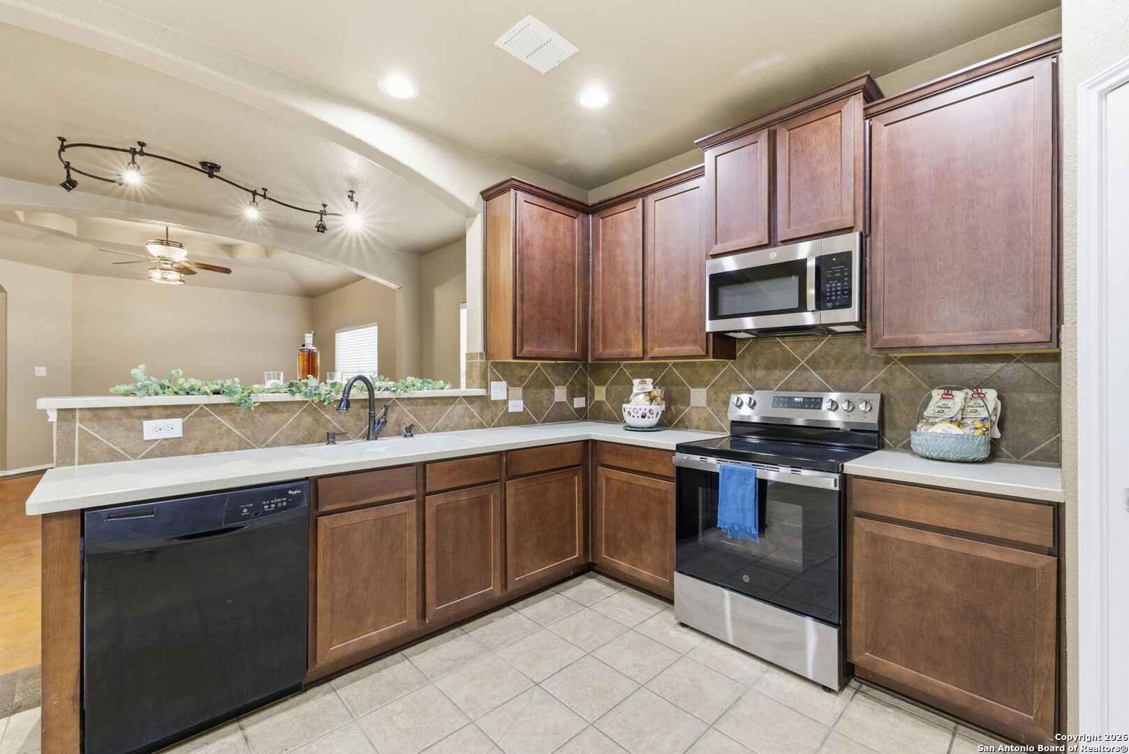 10510 Corvey Lane Helotes, TX 78023 - Photo 20 of 40 a kitchen with kitchen island granite countertop wooden cabinets stainless steel appliances and a counter space