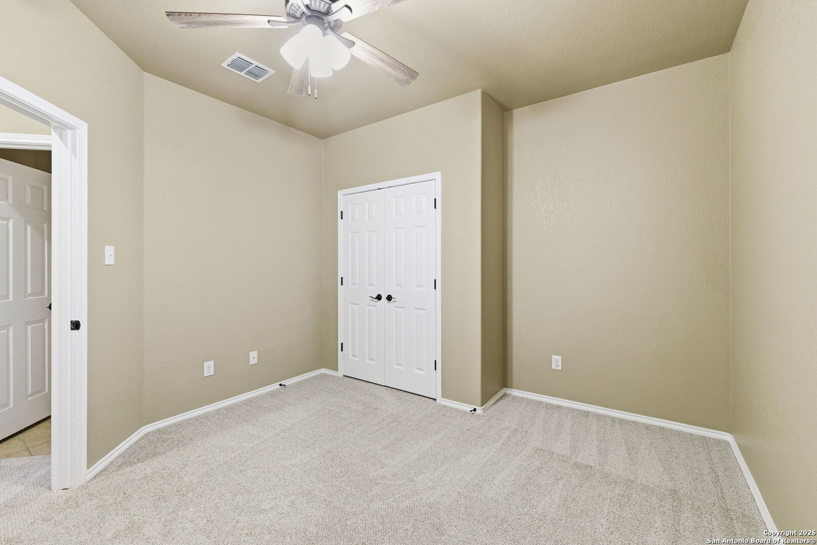 10510 Corvey Lane Helotes, TX 78023 - Photo 9 of 40 an empty room with a chandelier fan and a bathroom