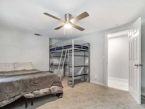 a bedroom with a bed and a ceiling fan