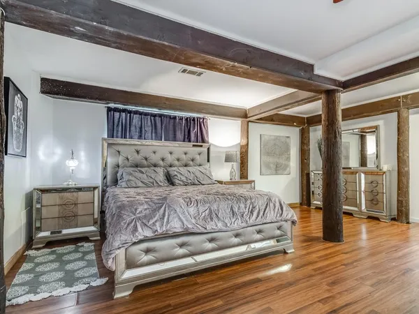 a bedroom with a bed and wooden floor