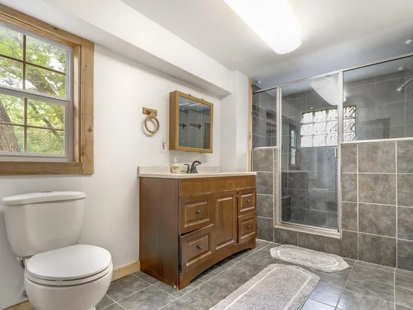 a bathroom with a double vanity sink toilet and shower