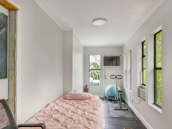 a bedroom with a bed and wooden floor