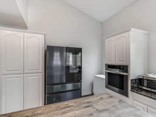 a kitchen with stainless steel appliances granite countertop a refrigerator and a stove top oven