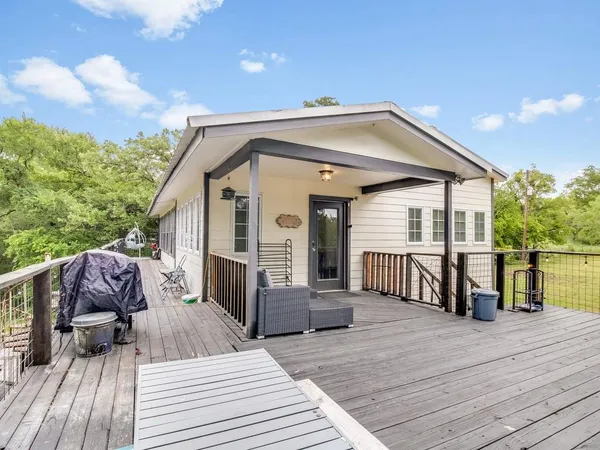 a view of a house with wooden deck and furniture