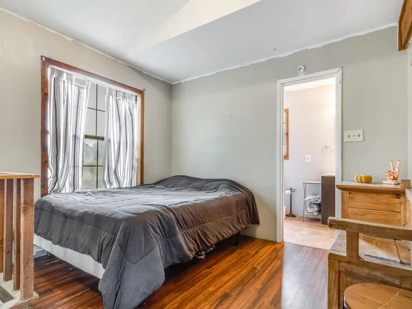a bedroom with a bed and wooden floor