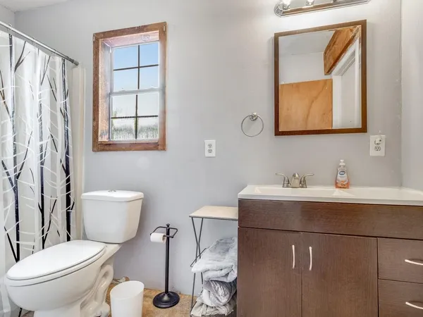 a bathroom with a toilet sink and mirror