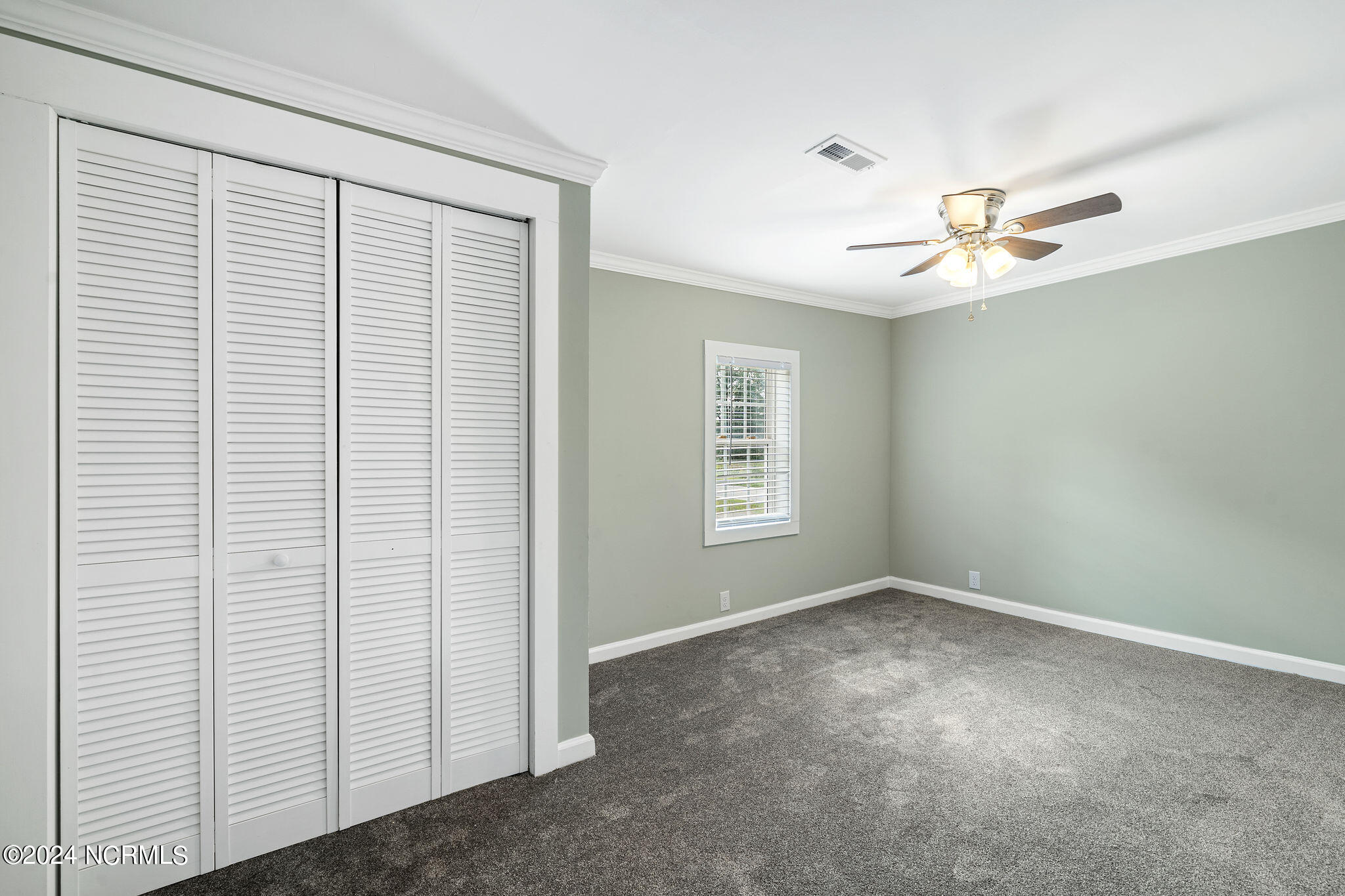 287 Murphys Store Road Rose Hill, NC 28458 - Photo 11 of 27 Bedroom One has a ceiling fan, a generously sized Closet with louvered doors and a window for lots of light