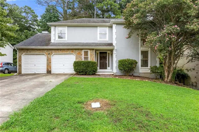 a front view of a house with a yard and garage
