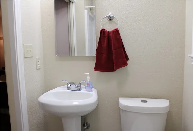 a bathroom with a sink a toilet and a mirror