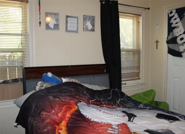 a bed sitting in a bedroom next to a window