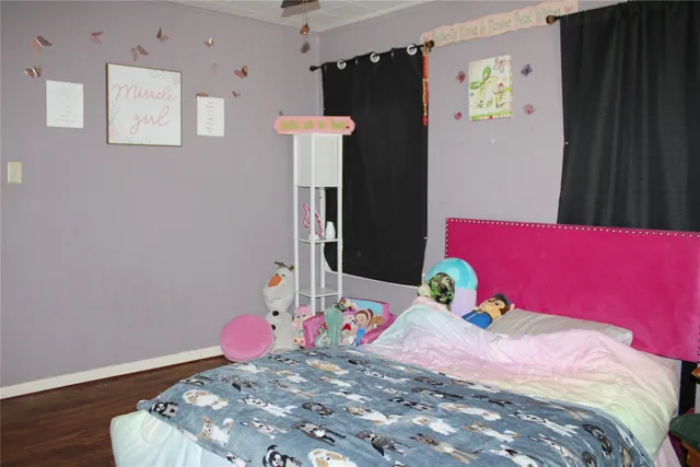 a bedroom with bed and wooden floor