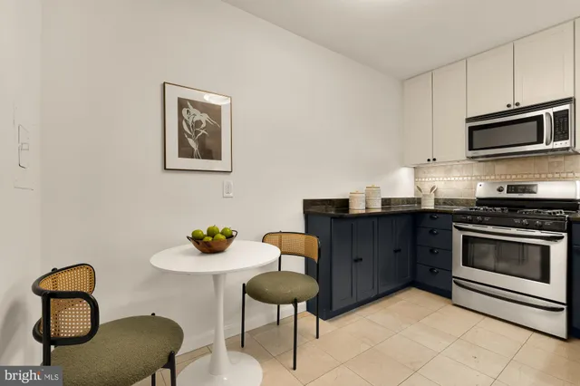 a kitchen with stainless steel appliances granite countertop a stove a microwave a sink and cabinets