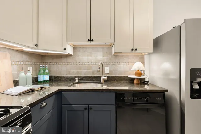 a kitchen with stainless steel appliances granite countertop a sink a stove and a refrigerator